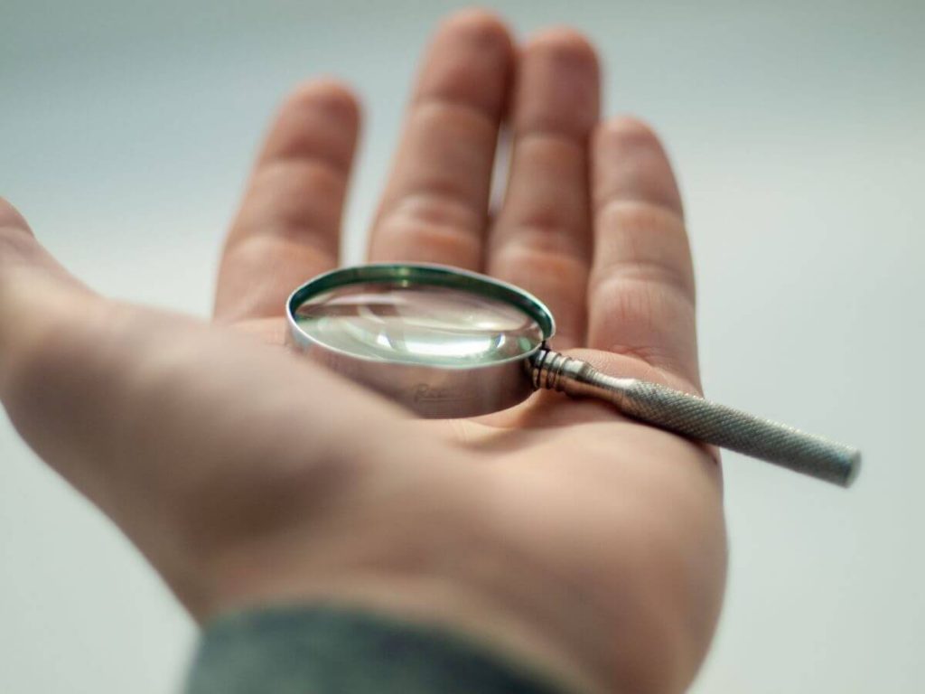 man holding out magnifying glass